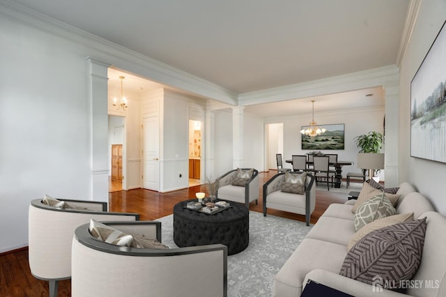 living room with ornamental molding, wood finished floors, decorative columns, and an inviting chandelier