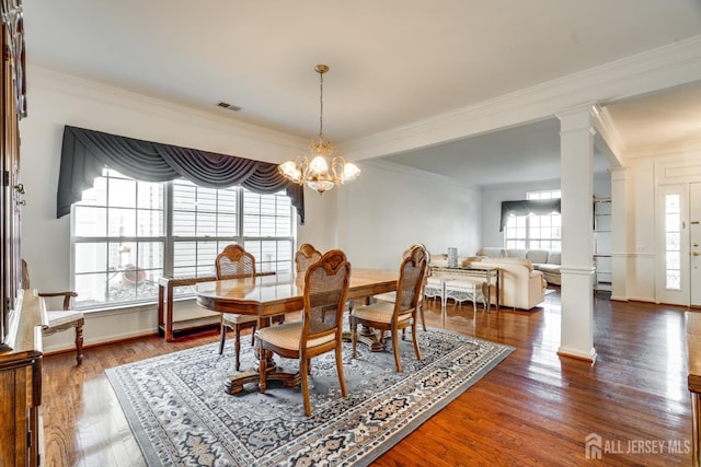 dining area with visible vents, an inviting chandelier, ornate columns, and wood finished floors