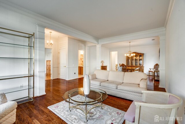 living room with ornate columns, ornamental molding, dark hardwood / wood-style floors, and a notable chandelier