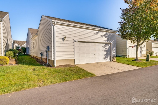 view of property exterior with an attached garage, a lawn, and driveway