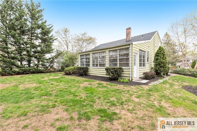 exterior space with a chimney and a yard