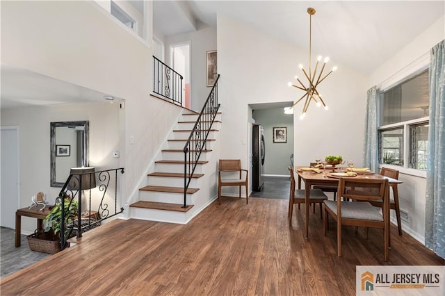 dining area with stairs, high vaulted ceiling, a chandelier, and wood finished floors