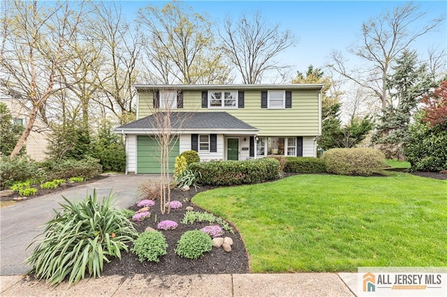 traditional home featuring a garage, driveway, roof with shingles, and a front lawn