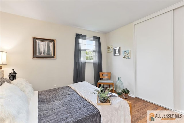 bedroom with baseboards, a closet, and wood finished floors