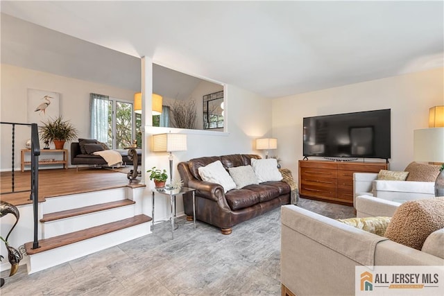 living room with baseboards and lofted ceiling