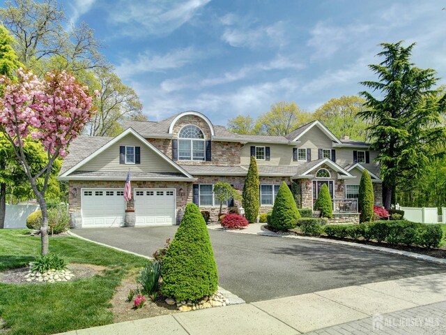 7 Willis Ct, East Brunswick, NJ 08816 - view of front of house with driveway, stone siding, and an attached garage