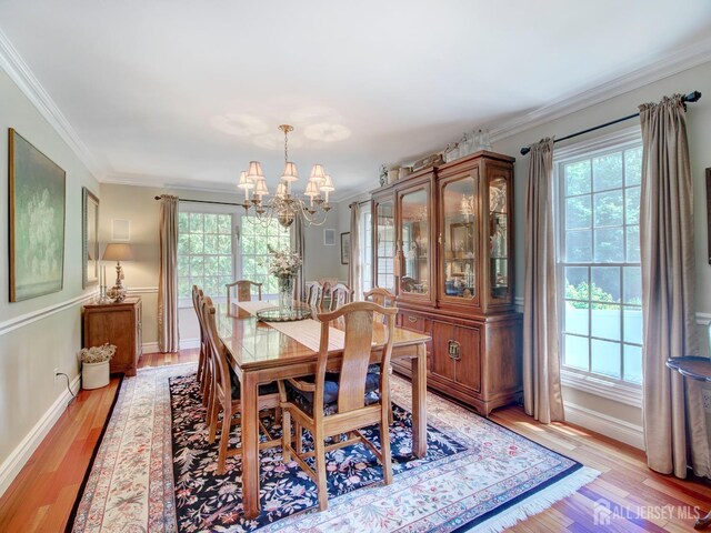 7 Willis Ct, East Brunswick, NJ 08816 - dining space with healthy amount of natural light, a chandelier, crown molding, and light wood finished floors