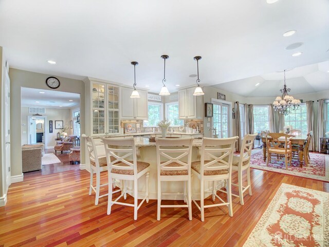 7 Willis Ct, East Brunswick, NJ 08816 - kitchen with light countertops, light wood-style flooring, a breakfast bar, glass insert cabinets, and recessed lighting