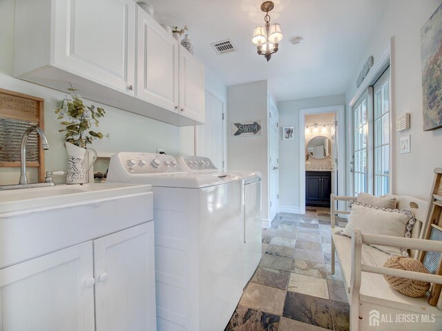 7 Willis Ct, East Brunswick, NJ 08816 - laundry area with cabinet space, stone tile flooring, washing machine and dryer, and a chandelier