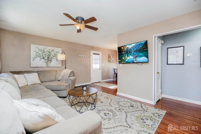 living room with dark wood-style floors, ceiling fan, and baseboards