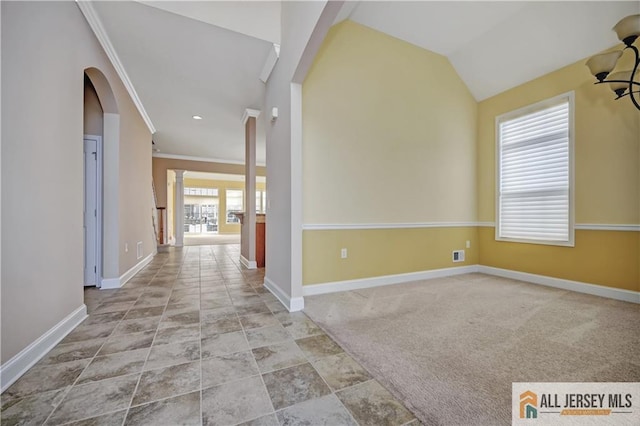 interior space featuring ornamental molding, lofted ceiling, and ornate columns