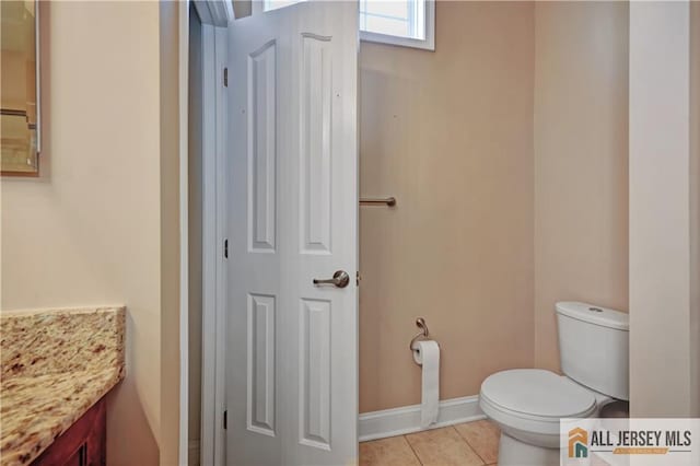 bathroom featuring tile patterned flooring, toilet, vanity, and baseboards