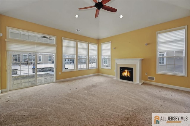 unfurnished living room featuring visible vents, a ceiling fan, recessed lighting, carpet floors, and baseboards