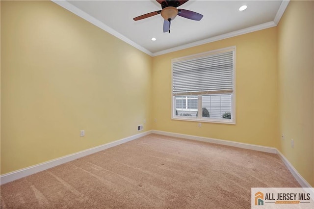 empty room featuring a ceiling fan, light colored carpet, baseboards, and ornamental molding