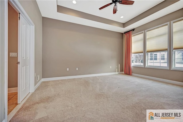 unfurnished room featuring light colored carpet, baseboards, and ceiling fan