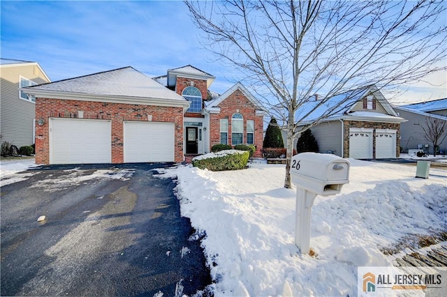 view of front facade featuring driveway, brick siding, and an attached garage