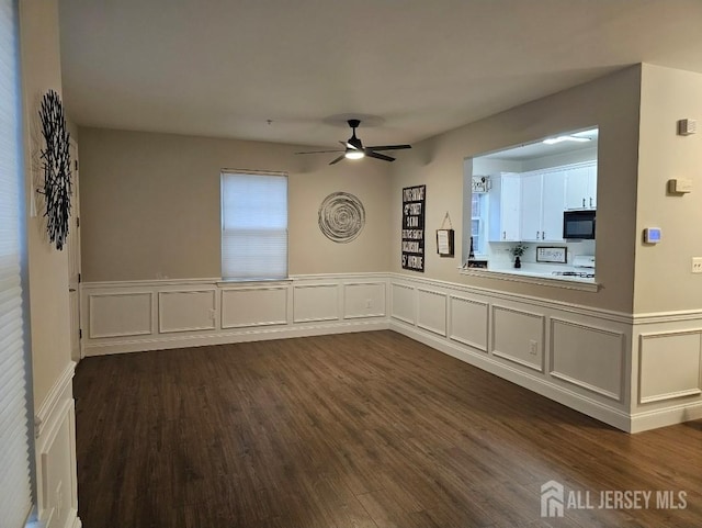 16 Park Sq, Metuchen, NJ 08840 - empty room with ceiling fan, dark wood-style flooring, a decorative wall, and a wainscoted wall