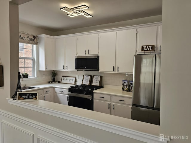 16 Park Sq, Metuchen, NJ 08840 - kitchen with appliances with stainless steel finishes, tasteful backsplash, white cabinets, and light countertops