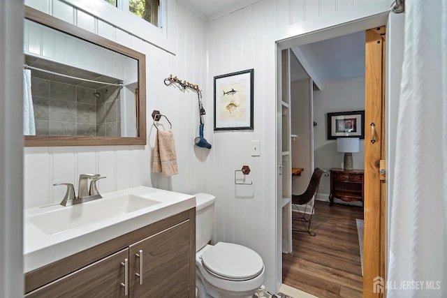 bathroom with hardwood / wood-style floors, vanity, toilet, and curtained shower