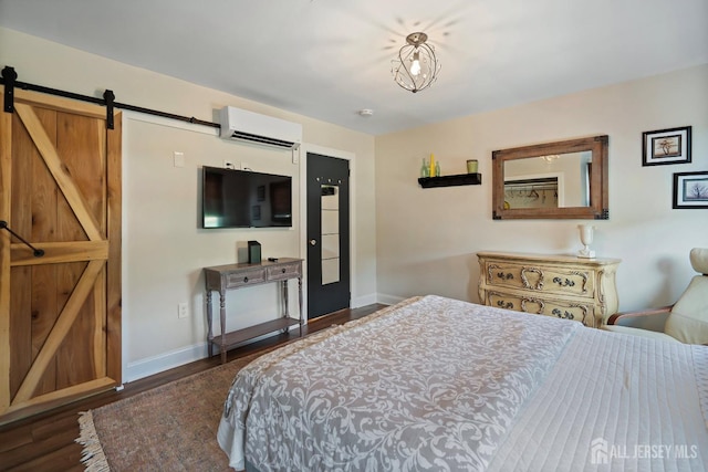 bedroom with a barn door, an AC wall unit, and dark wood-type flooring