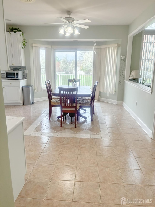 dining room featuring ceiling fan, light tile patterned floors, and baseboards