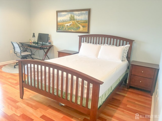 bedroom with wood finished floors and a desk