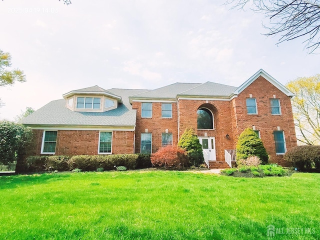 view of front of house featuring a front yard and brick siding