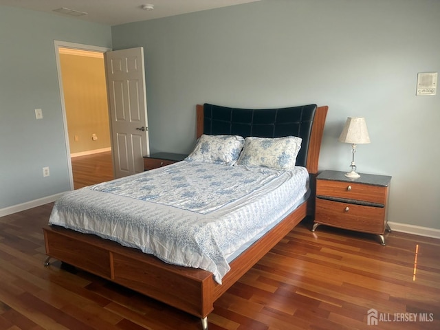 bedroom with wood finished floors and baseboards
