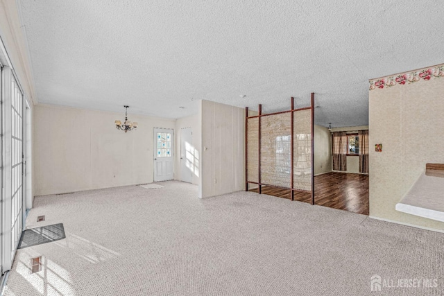 carpeted living room with a notable chandelier and a textured ceiling