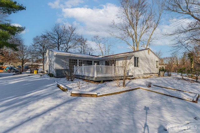 snow covered house featuring a wooden deck