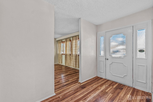 foyer with dark hardwood / wood-style floors and a textured ceiling