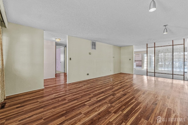 unfurnished room featuring dark hardwood / wood-style floors and a textured ceiling