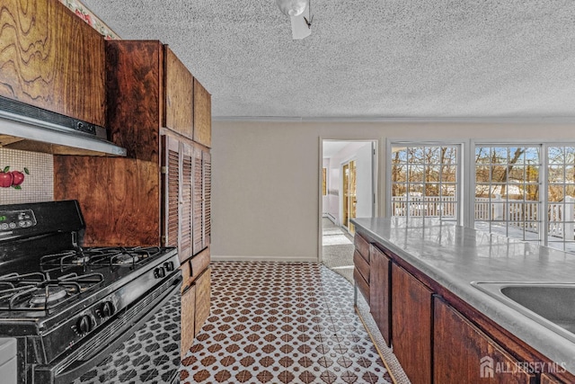 kitchen featuring range hood, sink, a textured ceiling, and black range with gas cooktop