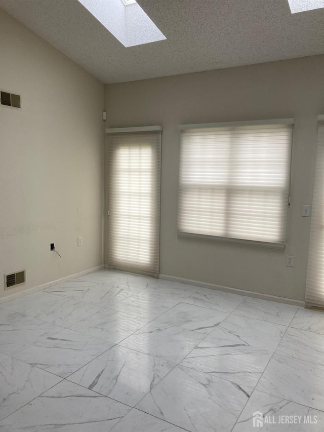 46 Chichester Rd, Monroe, NJ 08831 - empty room featuring a skylight, marble finish flooring, baseboards, and a textured ceiling