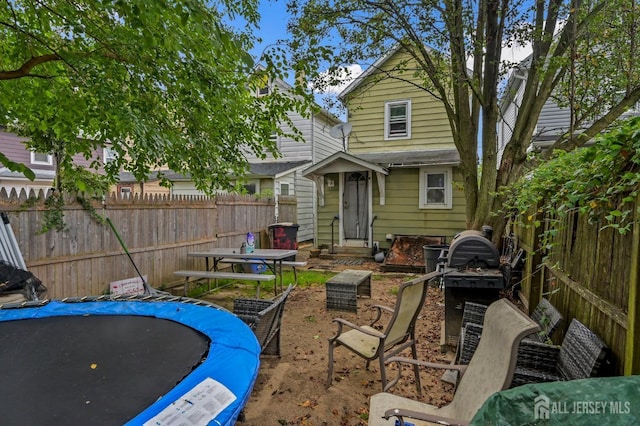 exterior space featuring entry steps, a fenced backyard, and a trampoline