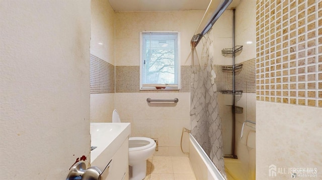 full bathroom with tile patterned floors, toilet, tiled shower / bath, tile walls, and vanity