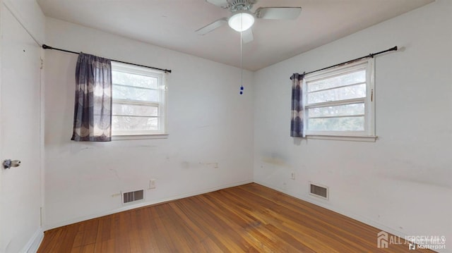 spare room with hardwood / wood-style flooring, a wealth of natural light, and ceiling fan