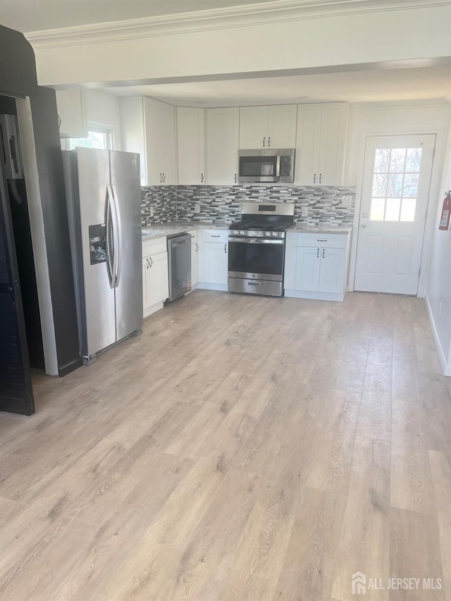 212 Huff Ave, Manville, NJ 08835 - kitchen with stainless steel appliances, backsplash, light countertops, light wood-style floors, and ornamental molding
