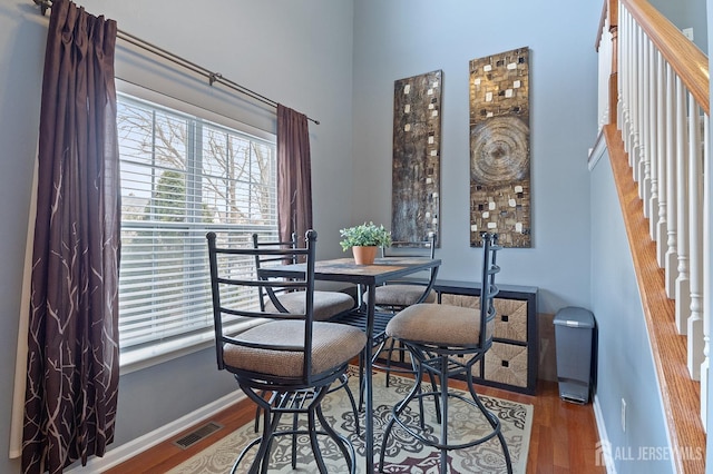 dining room featuring visible vents, baseboards, and wood finished floors