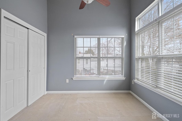 unfurnished bedroom with baseboards, carpet floors, a closet, and ceiling fan