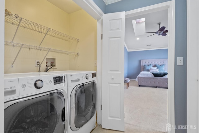 clothes washing area featuring laundry area, ceiling fan, crown molding, washing machine and dryer, and light colored carpet