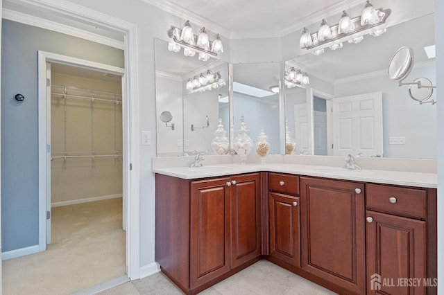 full bath featuring a sink, a walk in closet, double vanity, and crown molding