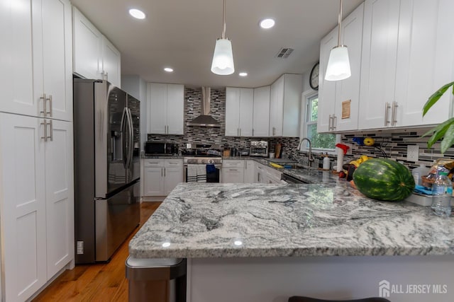 128 Jay St, Middlesex, NJ 08846 - kitchen featuring stainless steel appliances, wall chimney range hood, a sink, light stone counters, and decorative backsplash