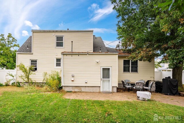 rear view of property featuring a yard and a patio