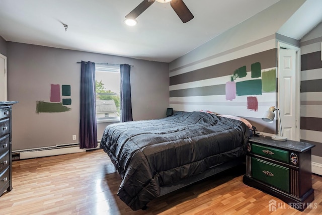 bedroom featuring a baseboard heating unit, light hardwood / wood-style flooring, ceiling fan, and lofted ceiling