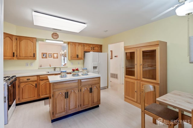 40 Rutland Ln Unit 40C, Monroe, NJ 08831 - kitchen with white refrigerator with ice dispenser, stove, a kitchen island, light wood-type flooring, and light countertops