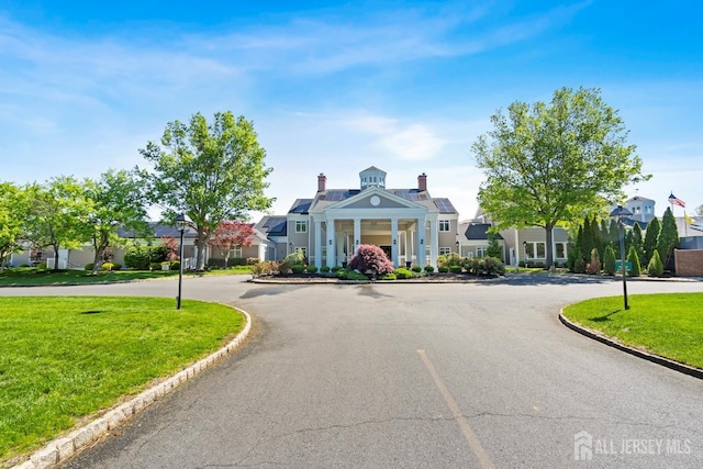 40 Rutland Ln Unit 40C, Monroe, NJ 08831 - view of front of home featuring a front lawn, solar panels, and a chimney