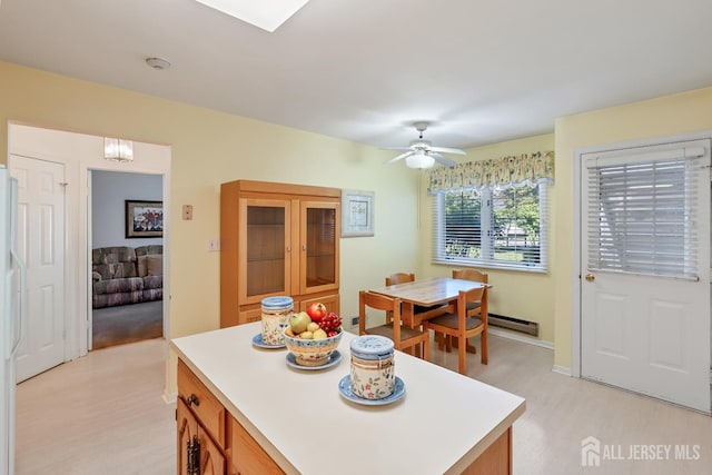40 Rutland Ln Unit 40C, Monroe, NJ 08831 - kitchen featuring light countertops, a baseboard heating unit, light wood-type flooring, brown cabinetry, and ceiling fan