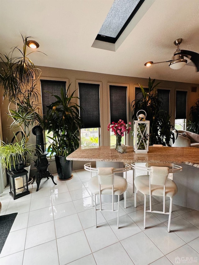 tiled dining area featuring a skylight