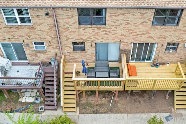 back of property with stairway and brick siding